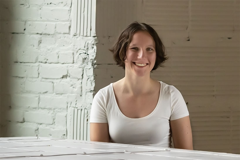 A person smiling with a white shirt